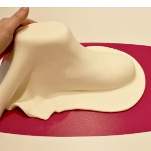 Knead 1kg of white Renshaw Extra sugarpaste and cover the carved boot cake using your hand to smooth around the contours of the cake.
