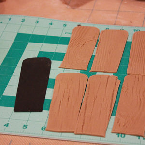 Using the wood grain texture mat, roll out tan fondant created by mixing ivory and brown fondant to the desired shade.