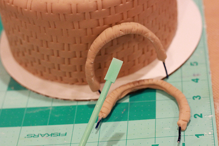 Create two small handles using wire and fondant, add texture and set aside to dry.