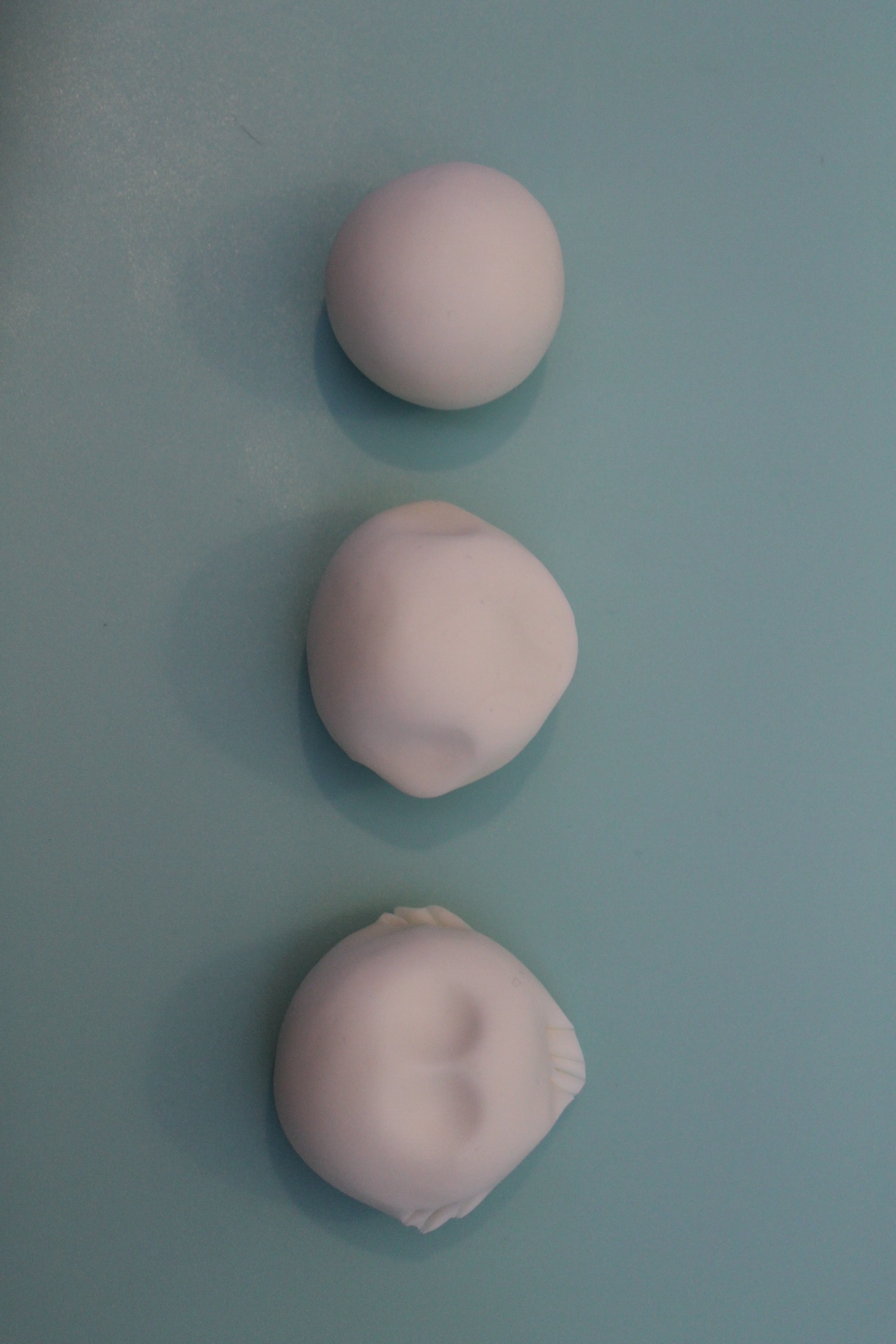 For the head, make a round ball of modelling paste, approximately a fifth of the body size. Pinch either side for the top of the furry jaw line and push your thumbs in at the centre slightly to create eye sockets. Use a dresden tool to draw lines at the very edge of each side of the face to create a fur effect.