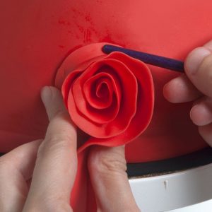 When the strip is finished, continue the spiral with another strip. Keep building up the rose with these strips until it has reached the desired size.