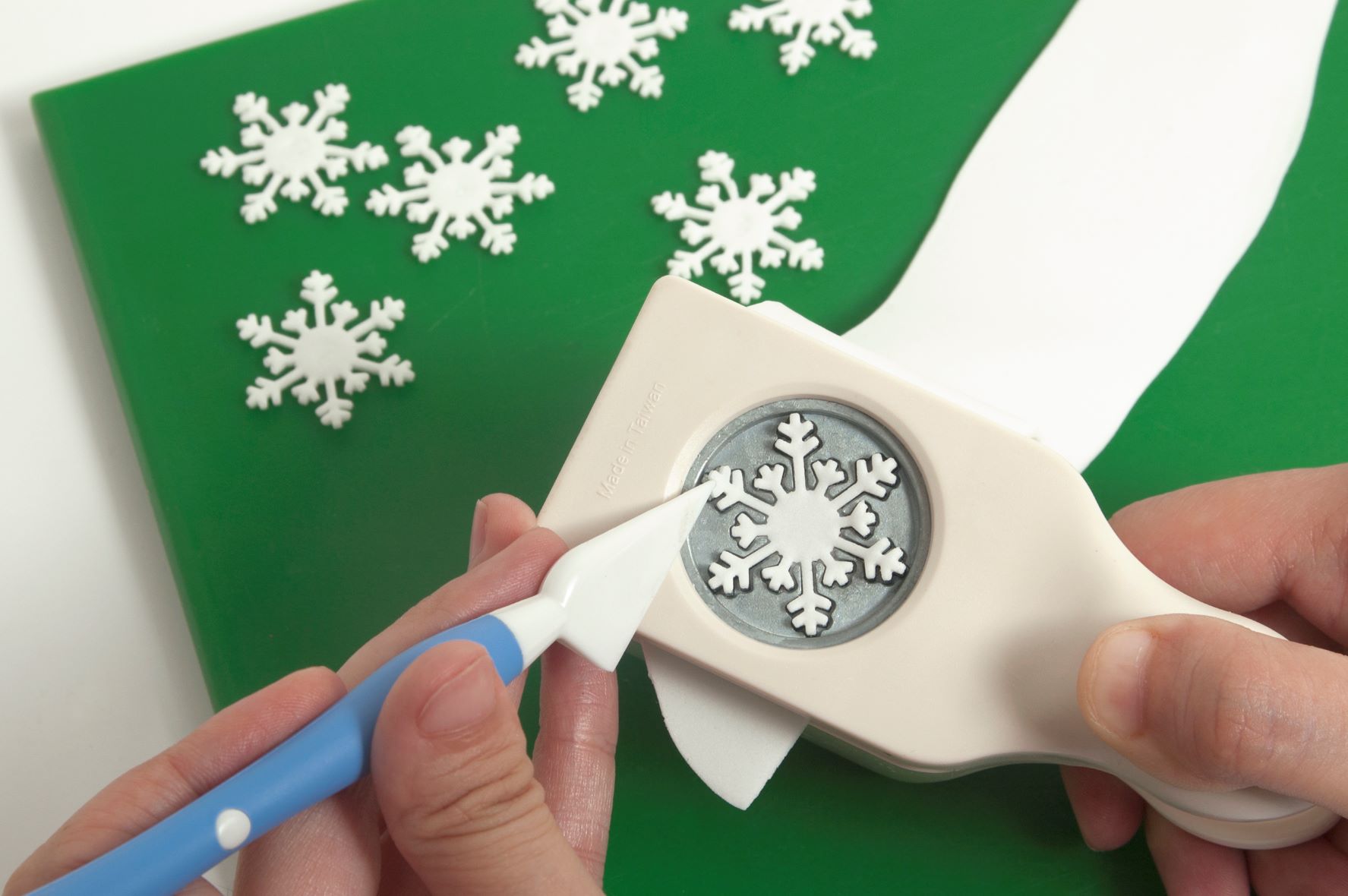 Cut out snowflakes with the paper punch.