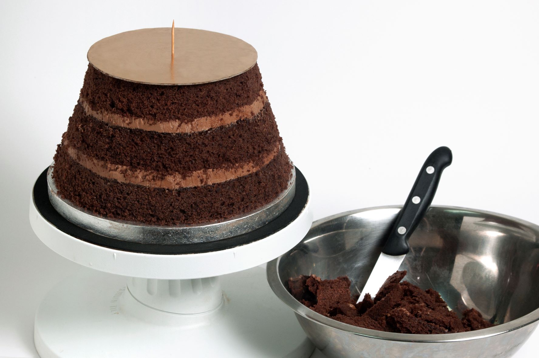 Place the 8” cake on a turntable and put the largest of the cake boards you have just trimmed on top.